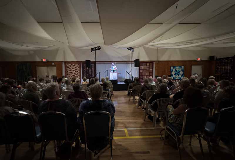 Back of the hall event with a speaker and crowd.